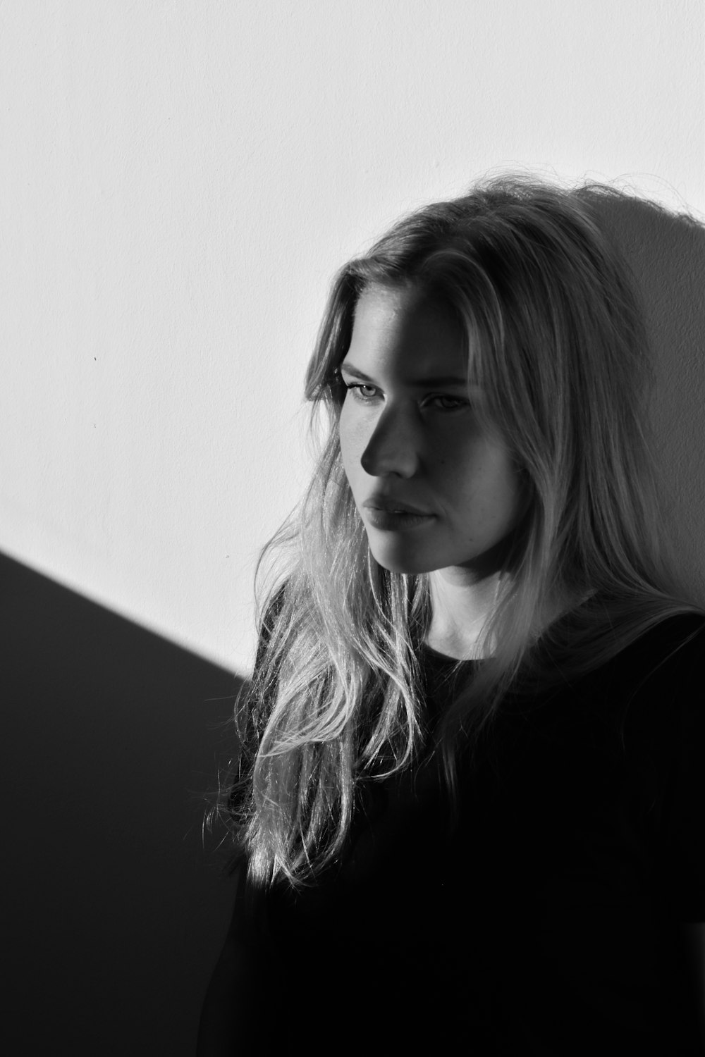 woman in black top leaning on wall