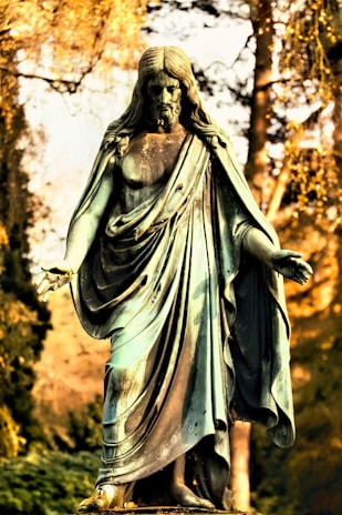 A delicate bronze statue of a Roman god with faded patina in a quiet setting