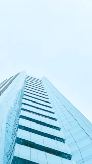 A sleek high-rise office building captured through smooth drone videography on a clear day.