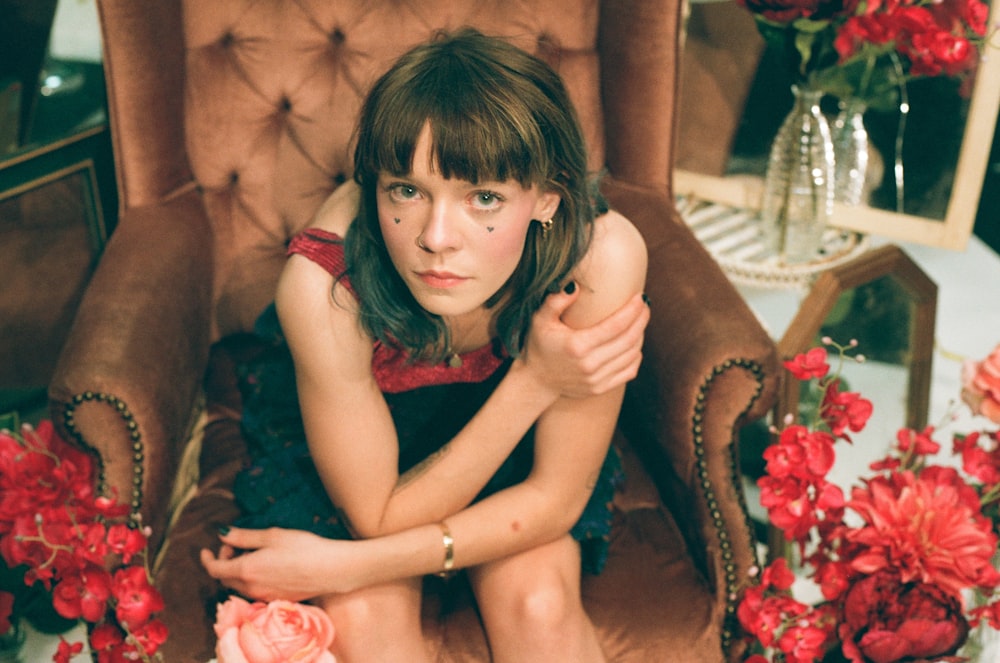 woman sitting on tufted brown sofa chair