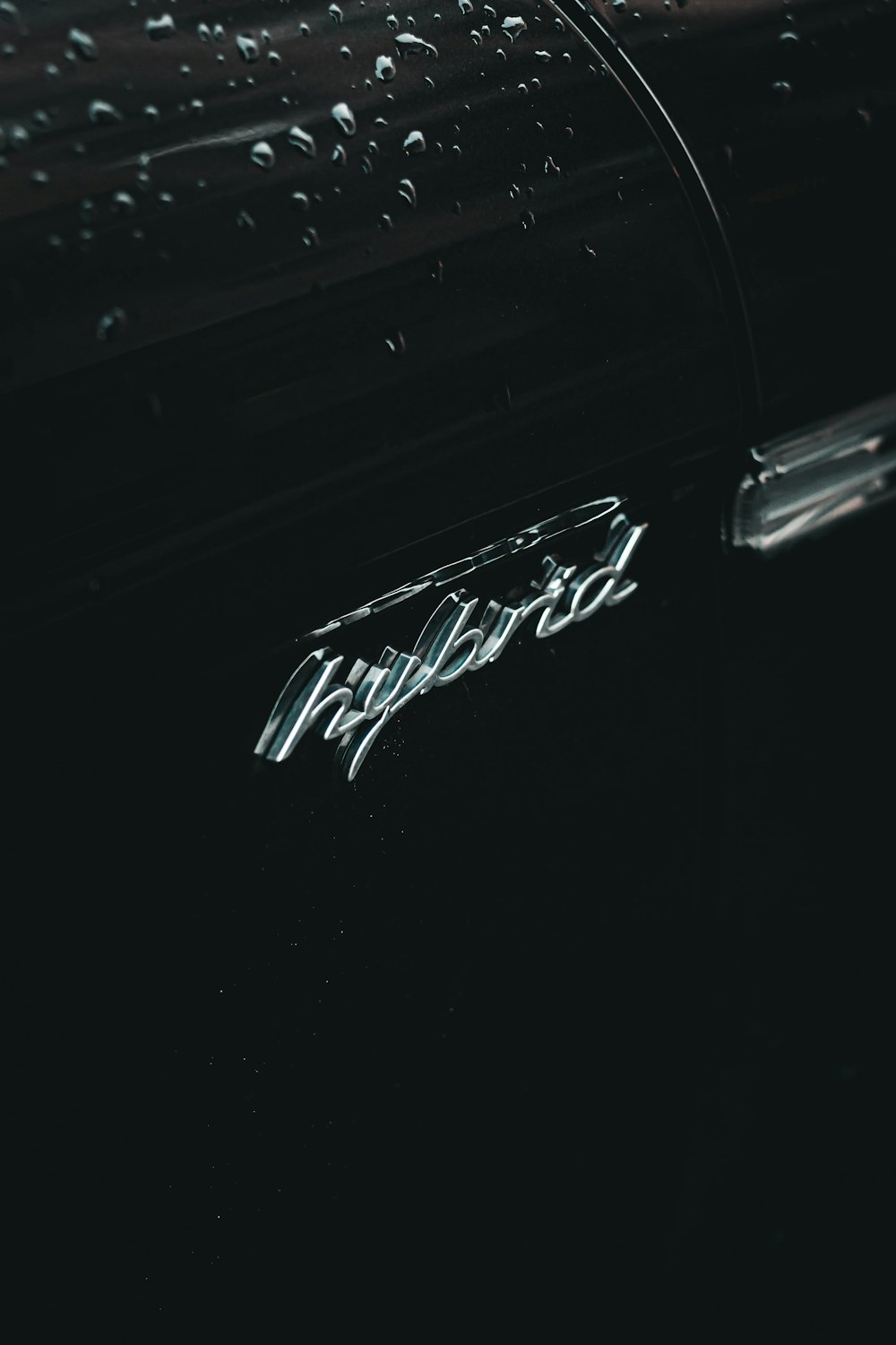 a close up of a car door with rain drops on it