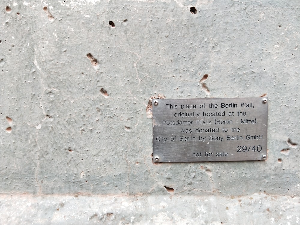 a plaque on the side of a cement wall