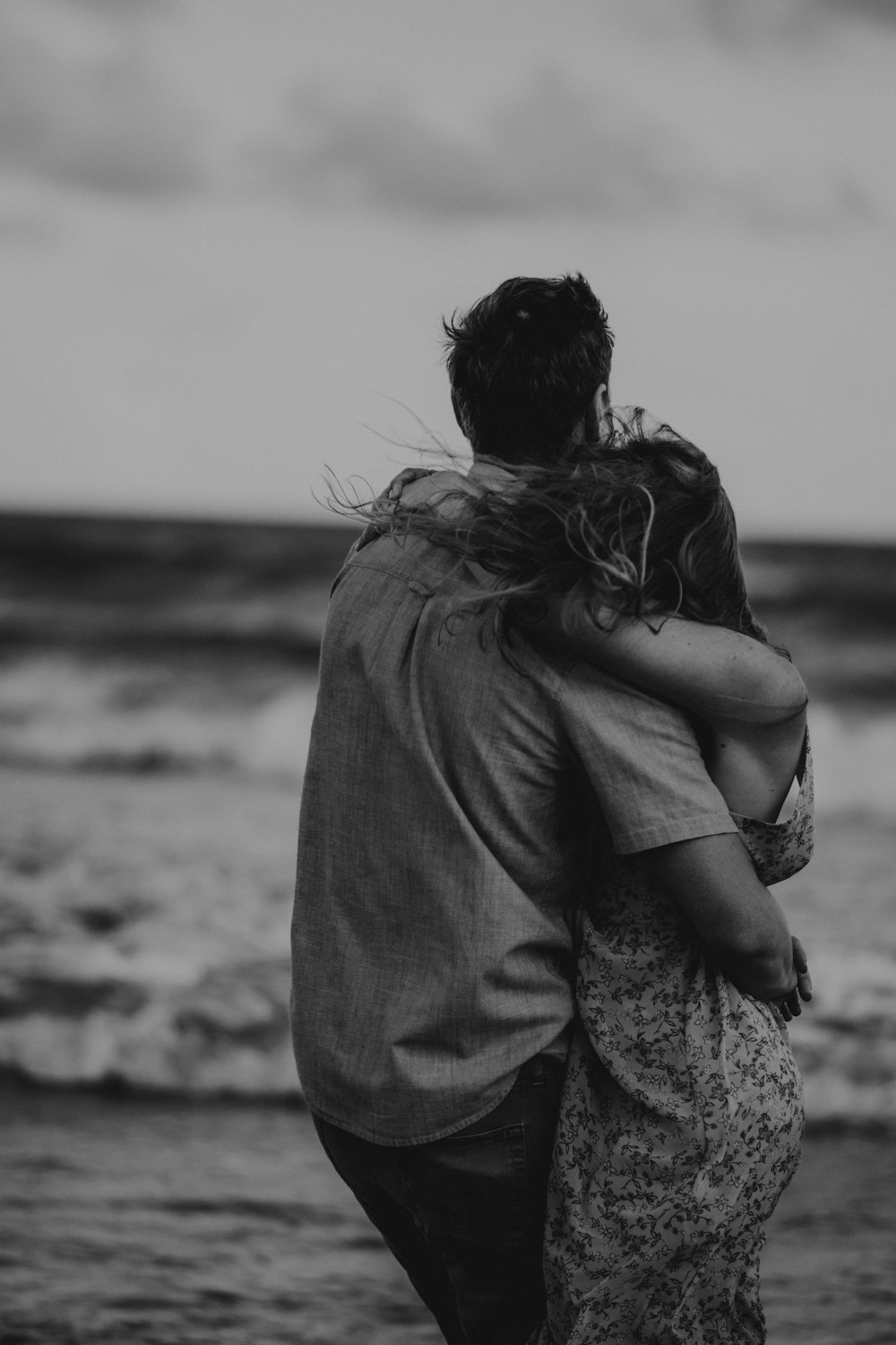 Photo en niveaux de gris d’un homme et d’une femme s’étreignant