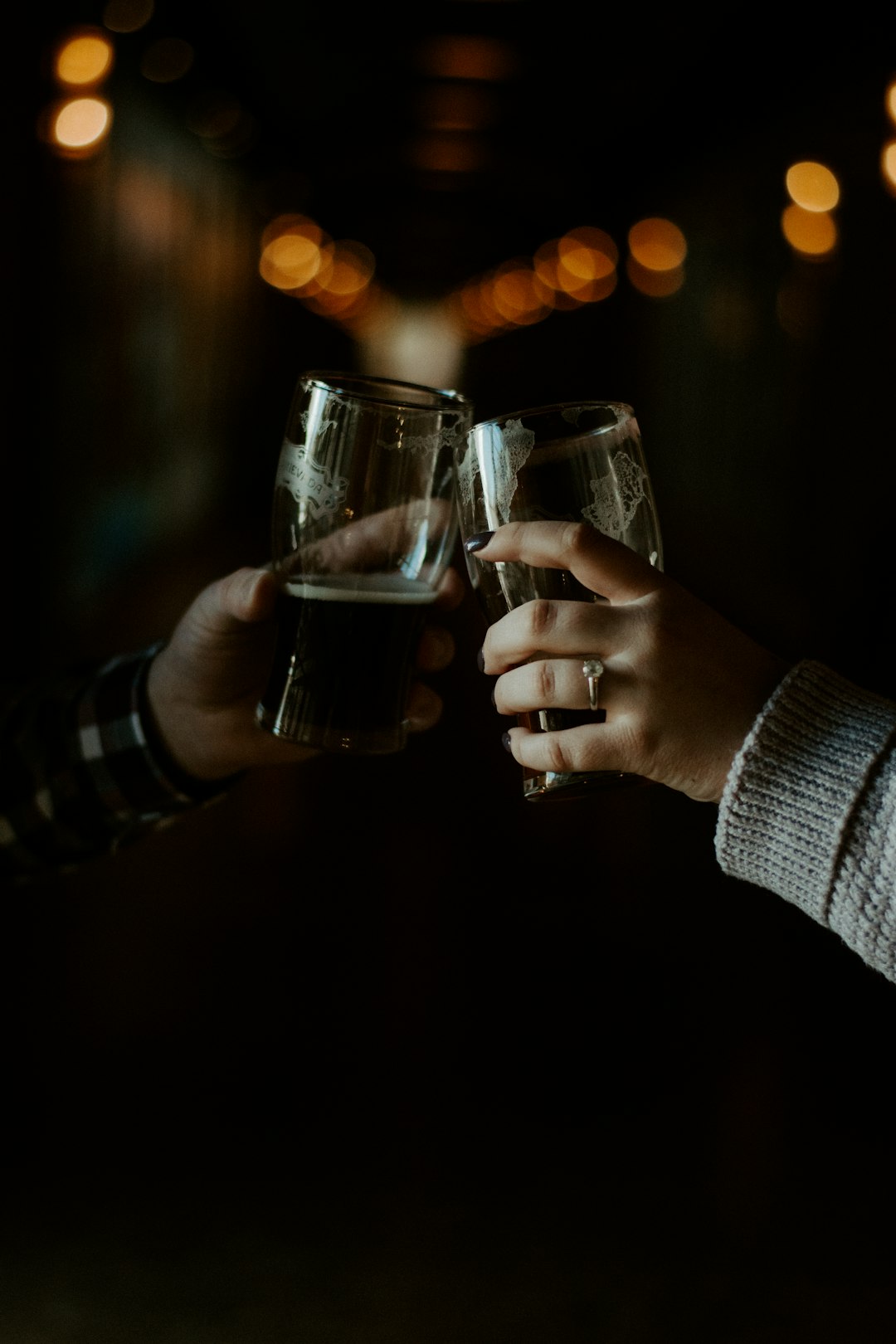 shallow focus photo of person holding drinking glass