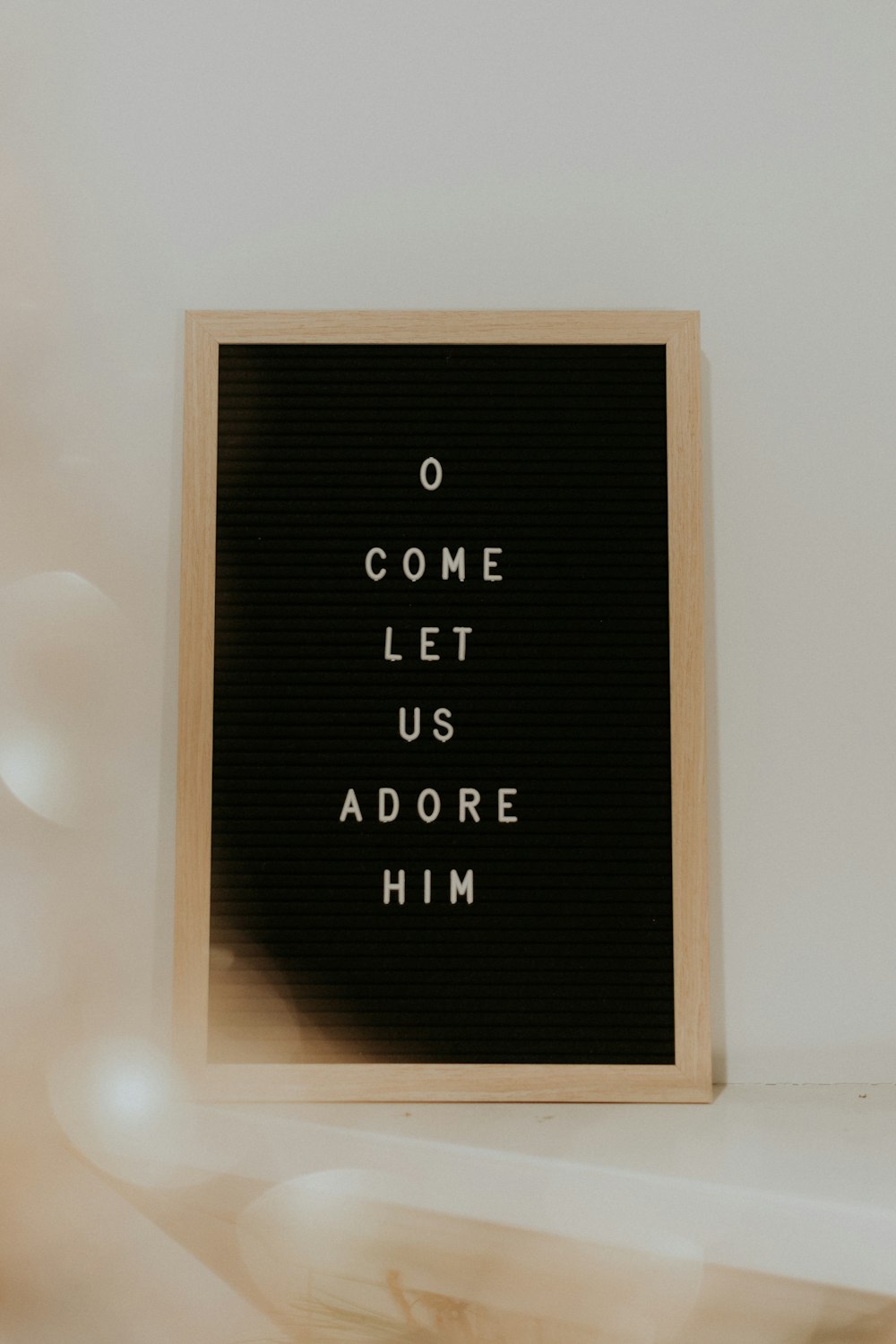 a black and white sign that says o come let us adore him