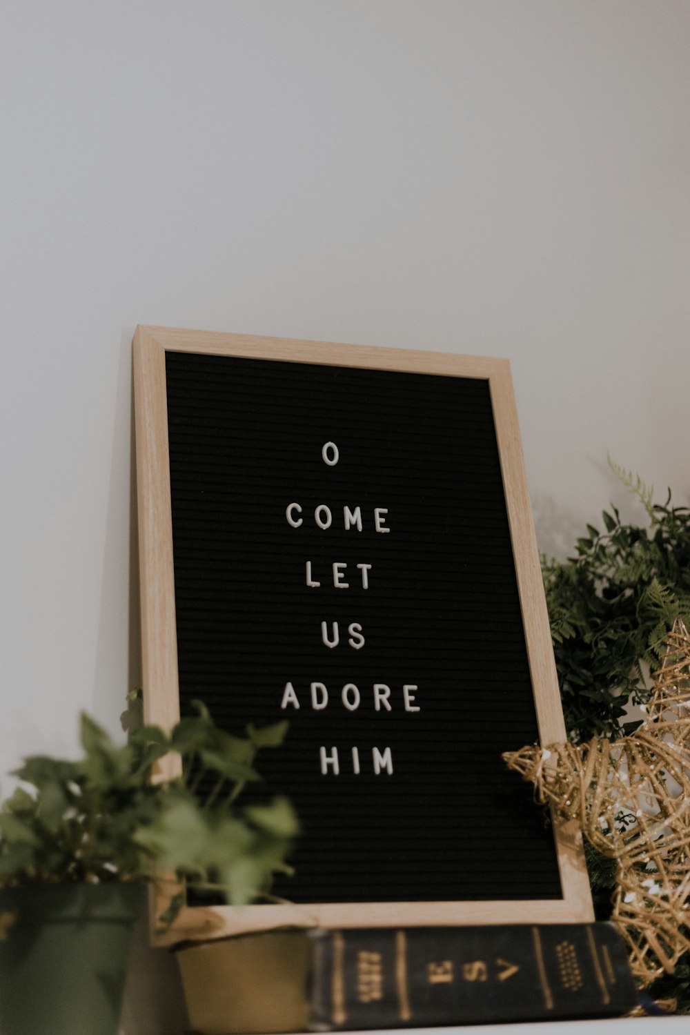 come let us adore him quote board with brown wooden frame