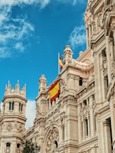yellow and red flag hanging on white building