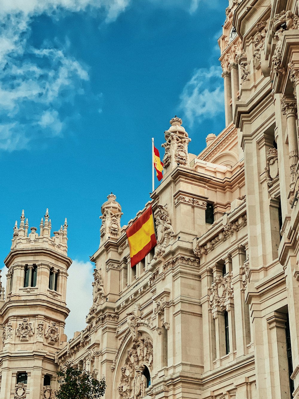 yellow and red flag hanging on white building