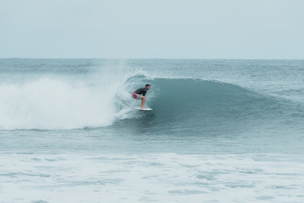 man surfing on seawave during daytime