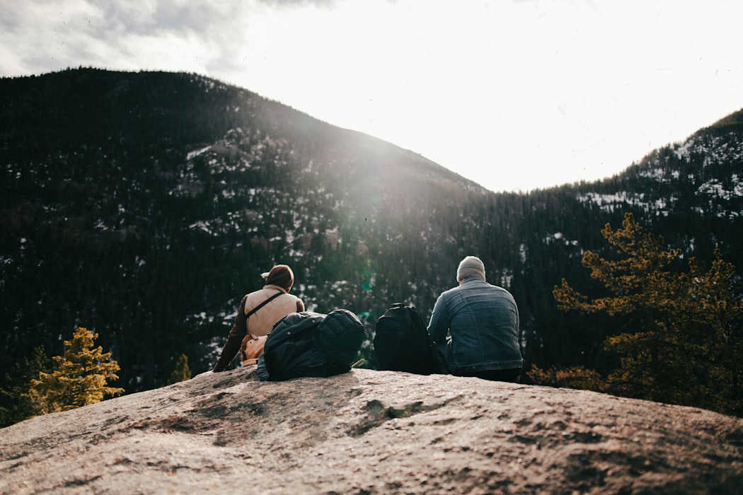 Man and woman sat wearing winter layers in Colorado National Park