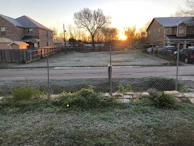 Sunrise over a suburban neighborhood with redviva network towers in the background.