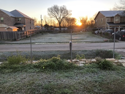 Sunrise over a developing suburban neighborhood with roads and plots.