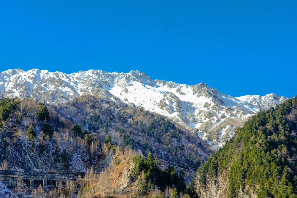 a snowy mountain range with a bridge in the foreground