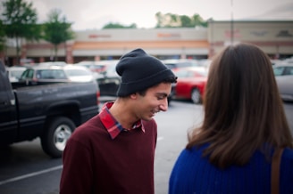 A friendly Line Design crew member chatting with a smiling client beside a striped parking lot.