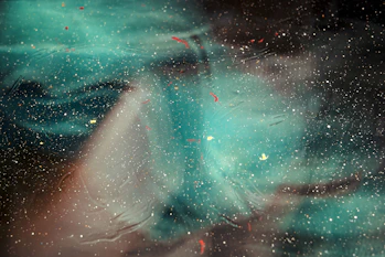 Abstract cosmic swirl in deep midnight blue with warm amber highlights.