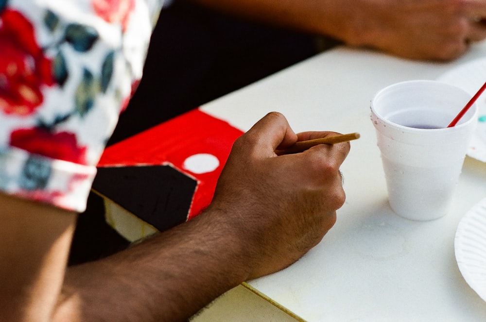 white disposable cup on white surface