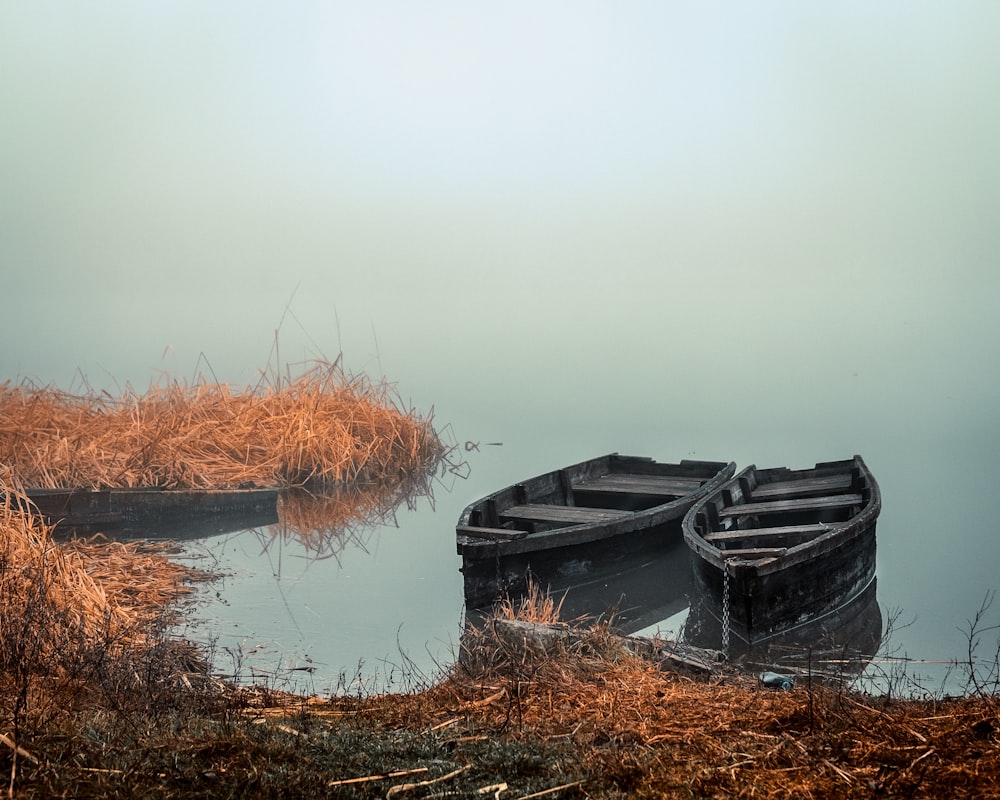 two gray wooden boats on dock