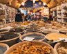 people walking beside pot of grains