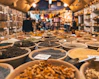 people walking beside pot of grains