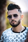 A stylish man wearing a distinctive pendant at an outdoor event.