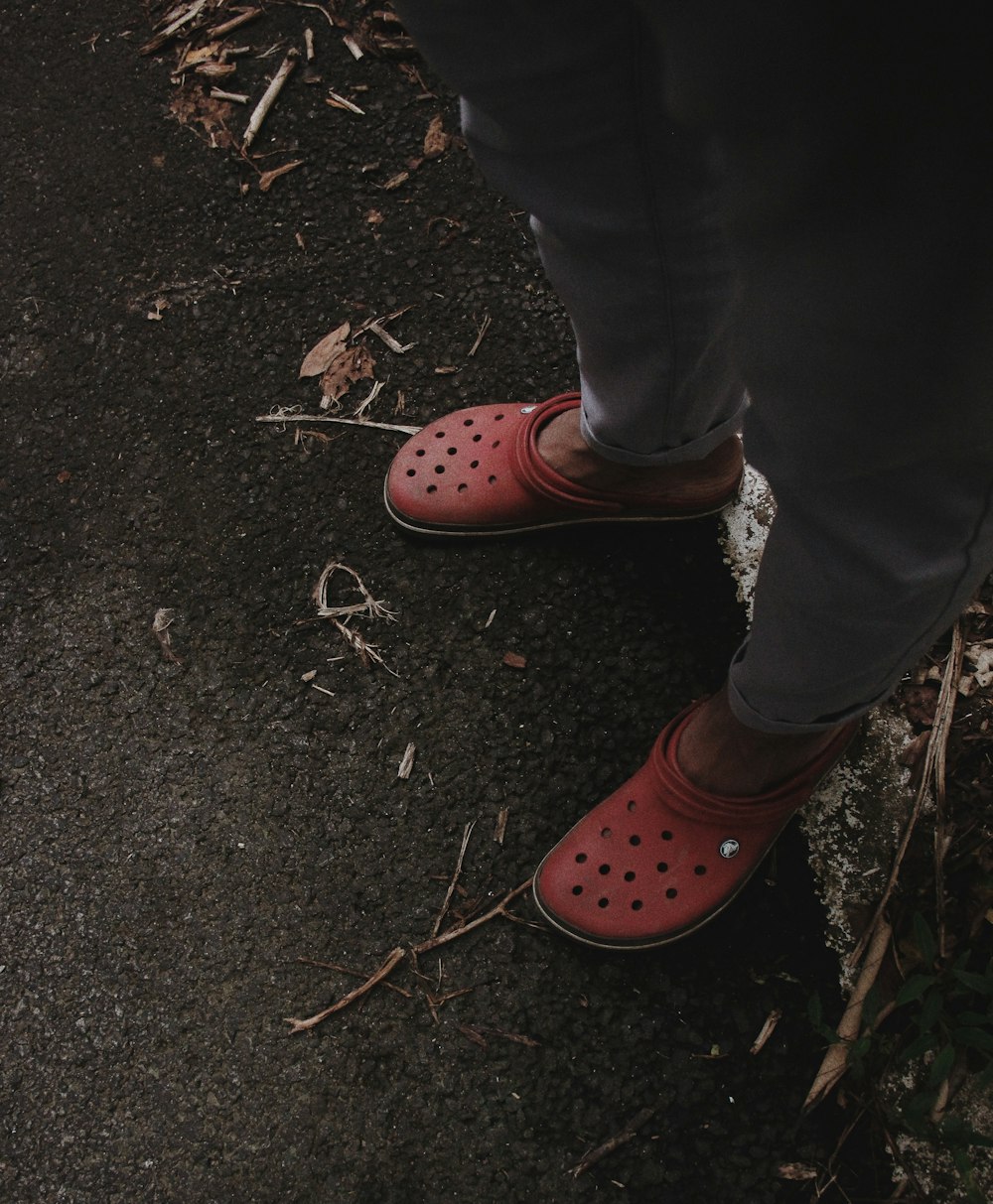 person wearing red Crocs rubber clogs