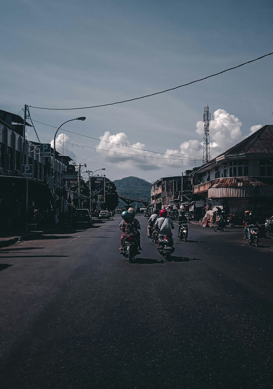 people riding motorcycles on road near people and buildings