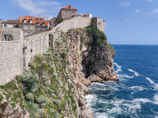 gray concrete buildings and wall near sea during daytime in Muralles de Dubrovnik Croatia