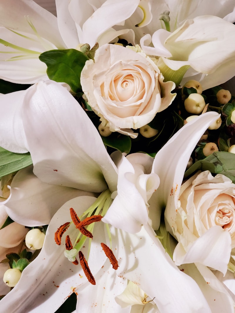 Elegant white and green sympathy arrangement with roses and lilies