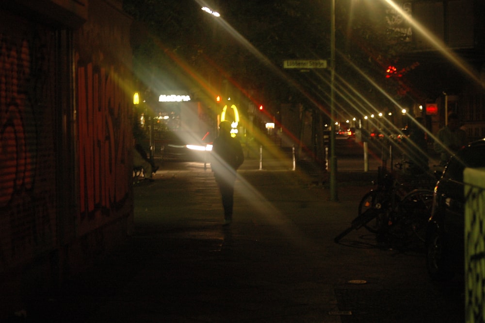 a person walking down a street at night