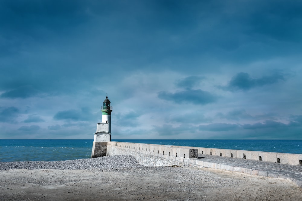 a light house sitting on the edge of a pier