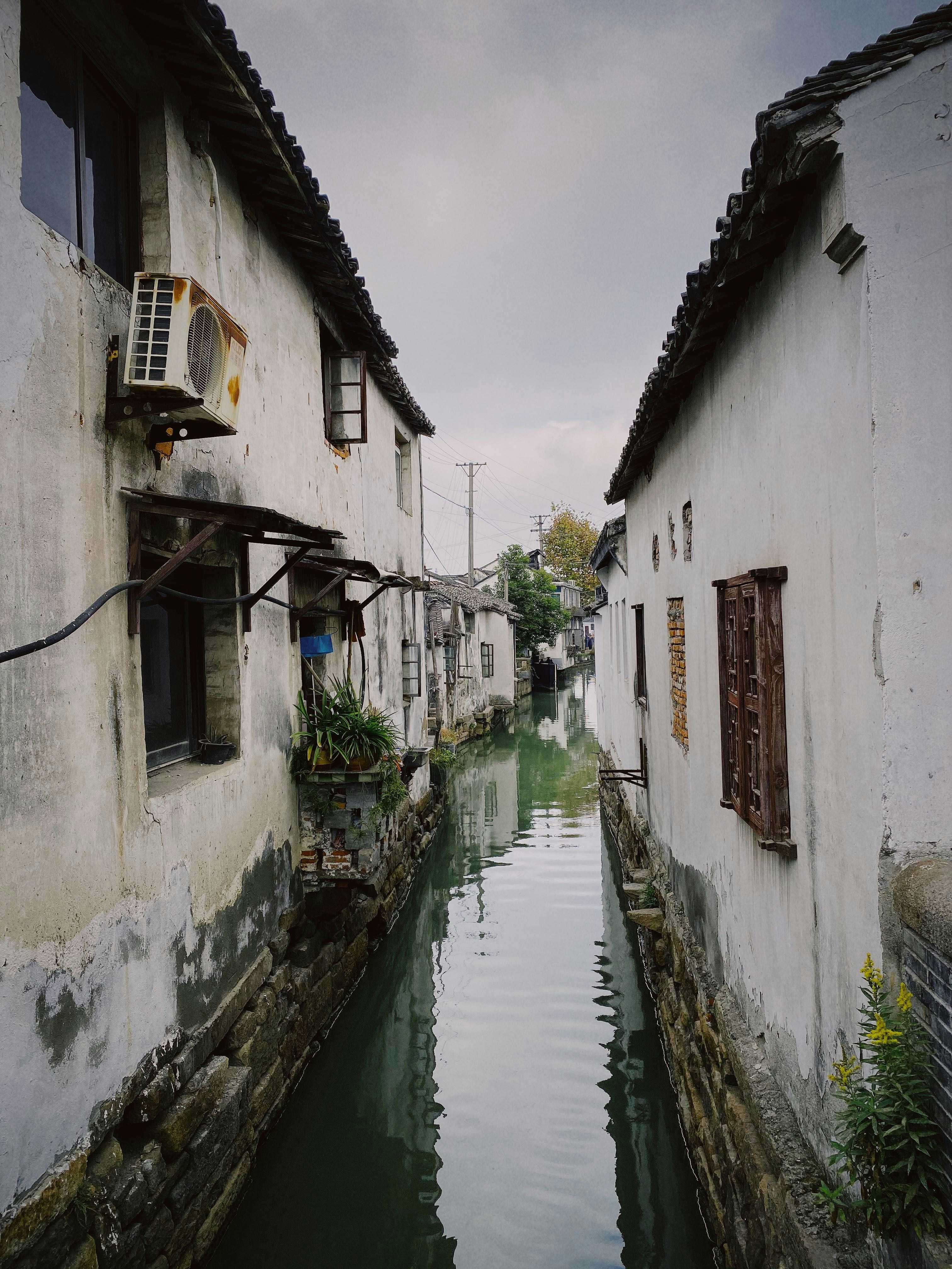 canal between buildings during day