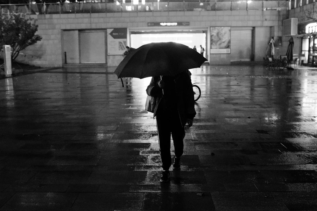 person using umbrella near building