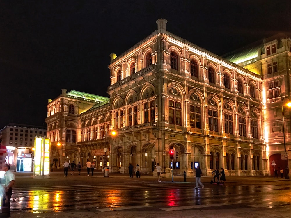 people walking on road near Vienna State Opera during night time