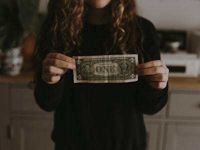 girl holding 1 u.s. dollar banknote note teams background