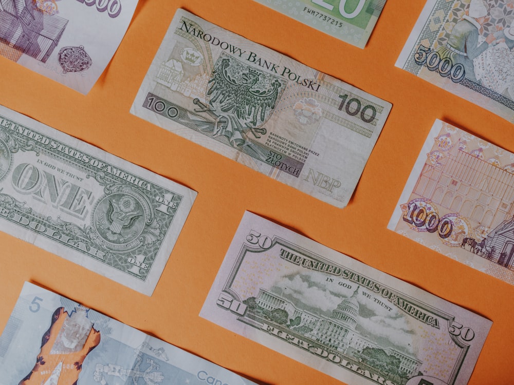 Assortiment de billets de banque sur surface orange