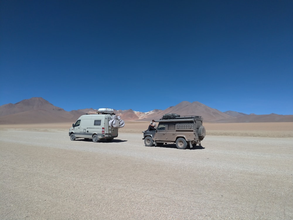 white van near another vehicle on desert