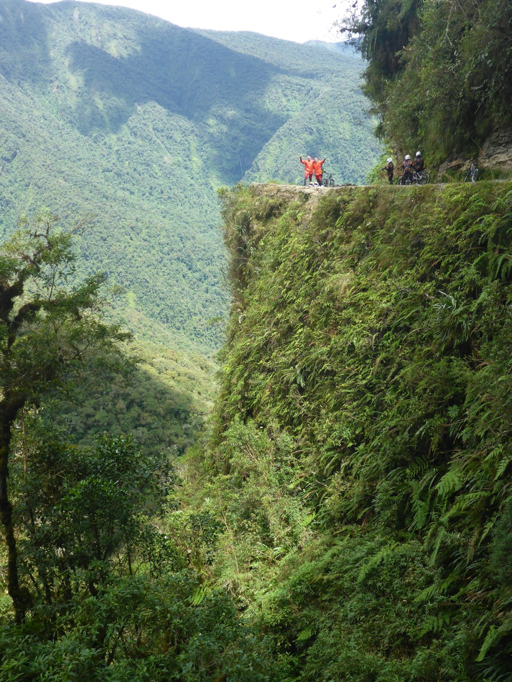 people on rocky hill viewing mountain during daytime