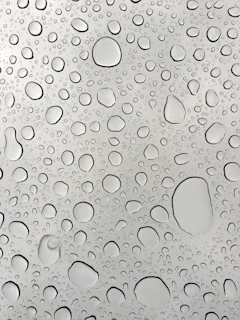 Close-up of a sparkling clean window pane with water droplets sliding off