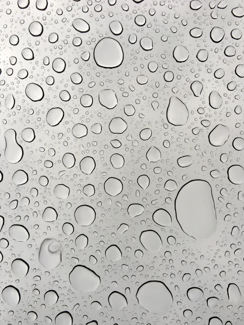 Close-up of a sparkling clean window pane with water droplets sliding off