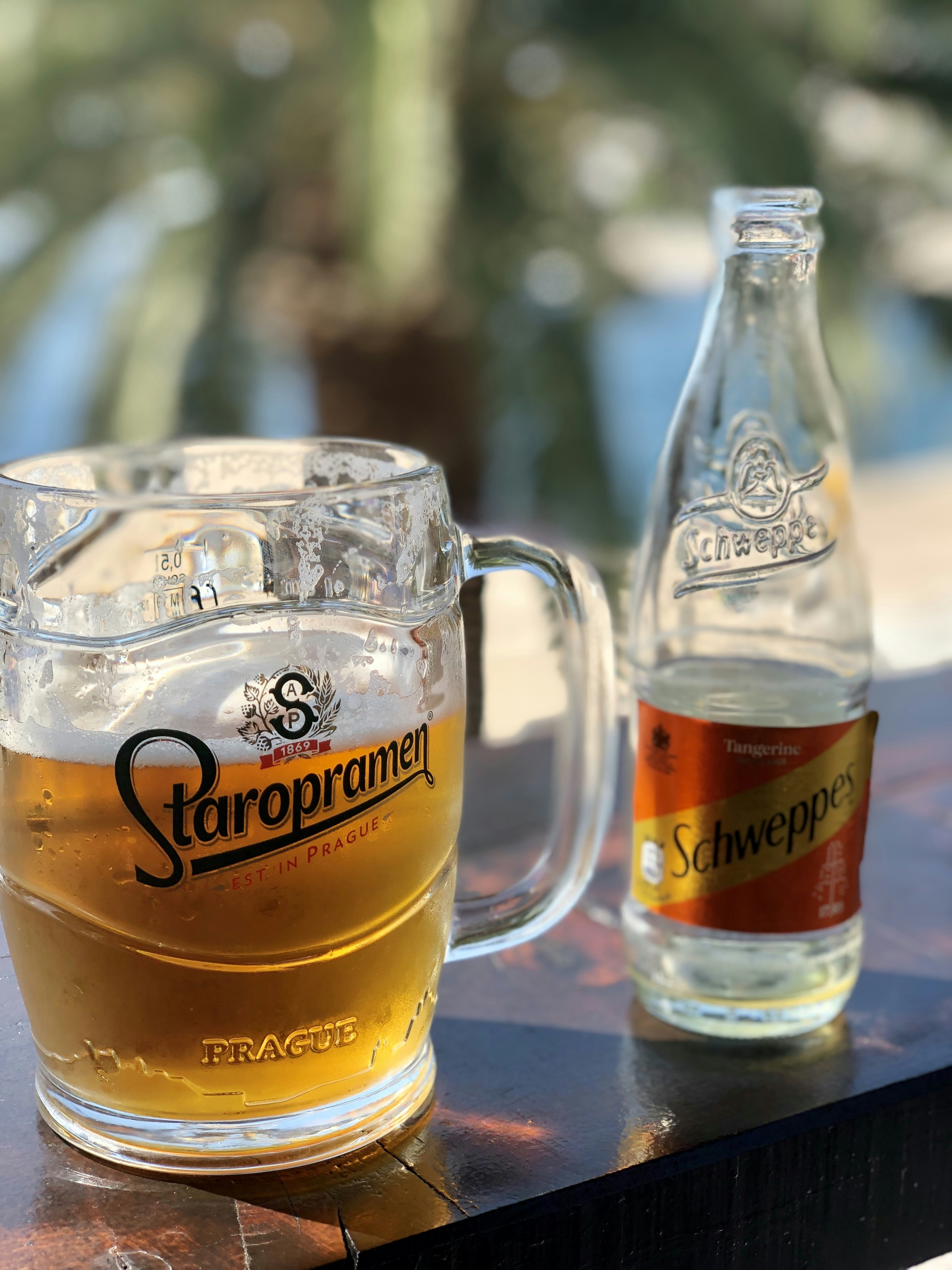 Schweppes bottle near glass of beer