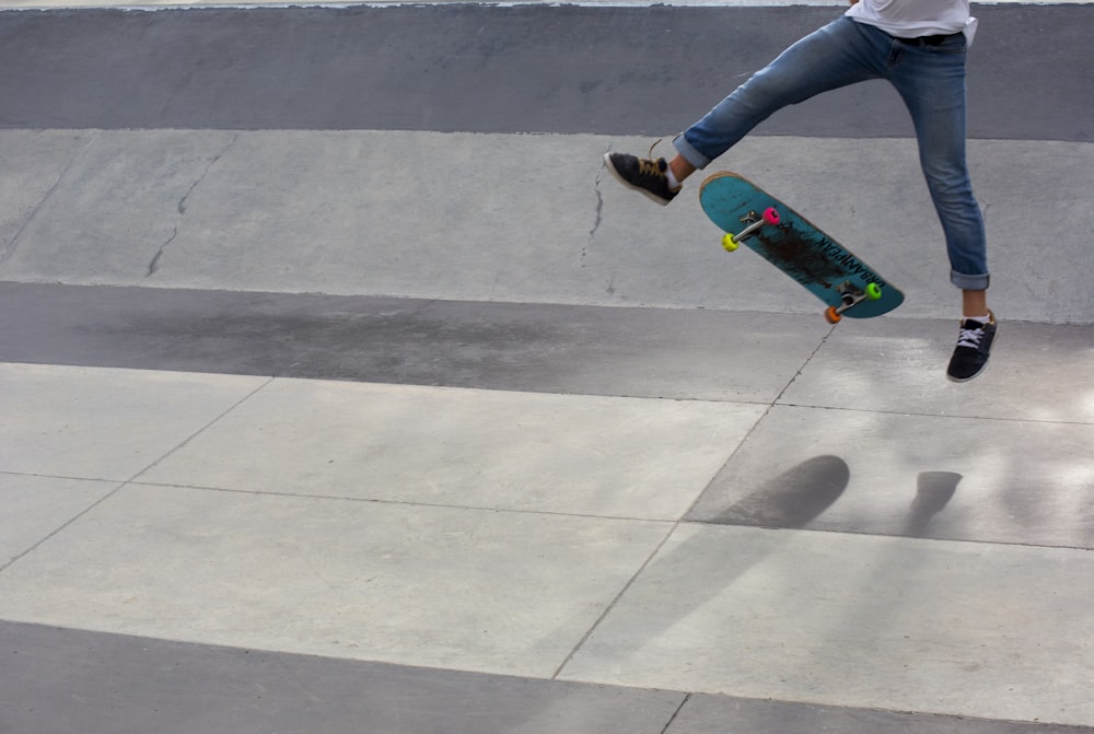 Persona che fa skateboard in jeans blu denim