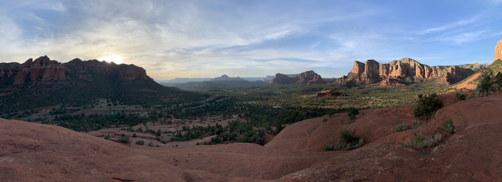 a scenic view of a valley with mountains in the background