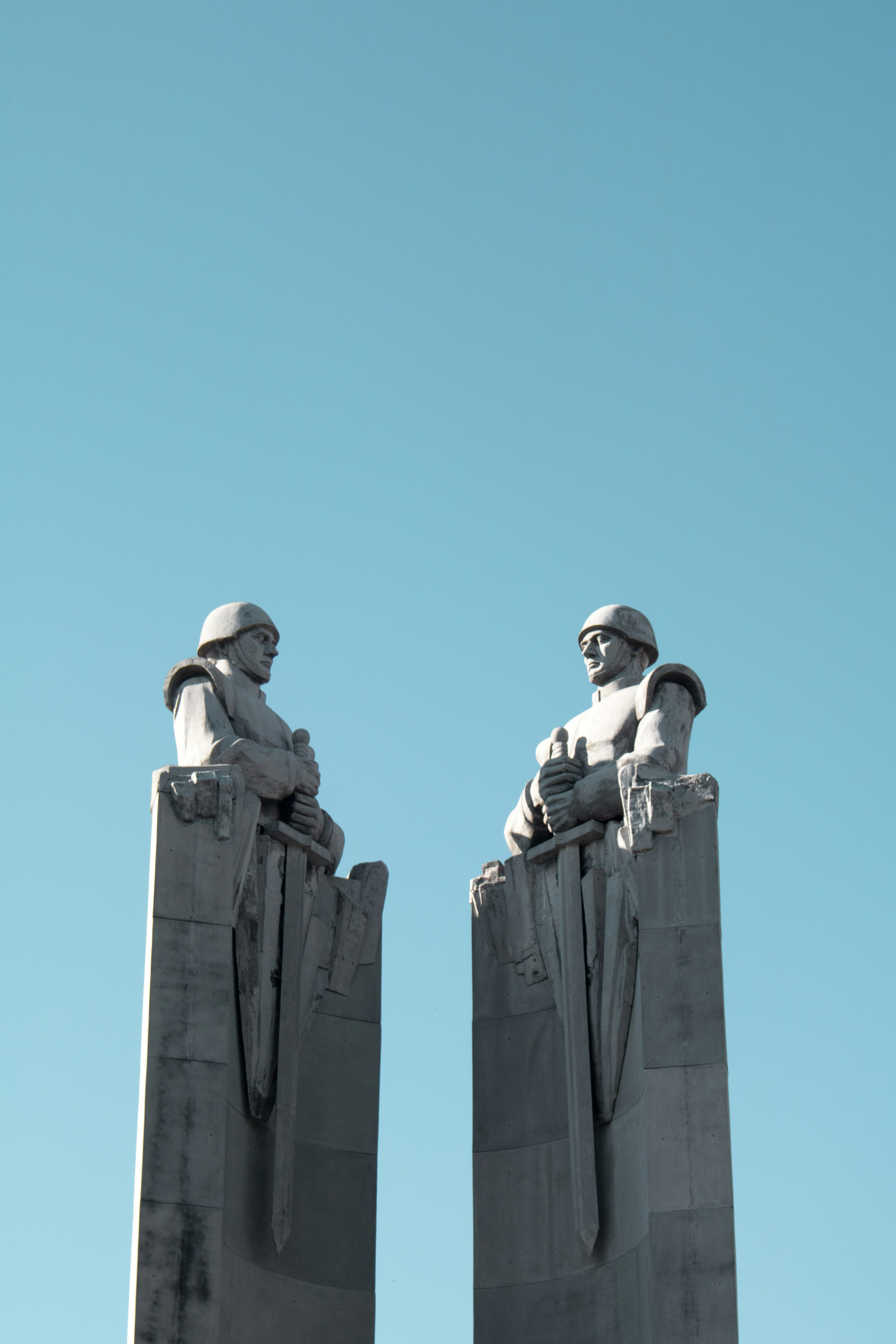 two man themed statues under blue sky