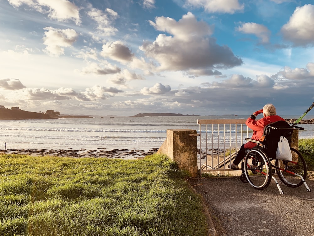 a man riding a bike next to the ocean