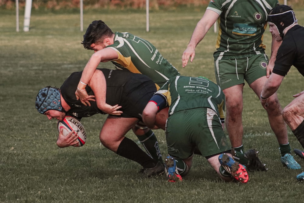 rugby players tackling each other while on field