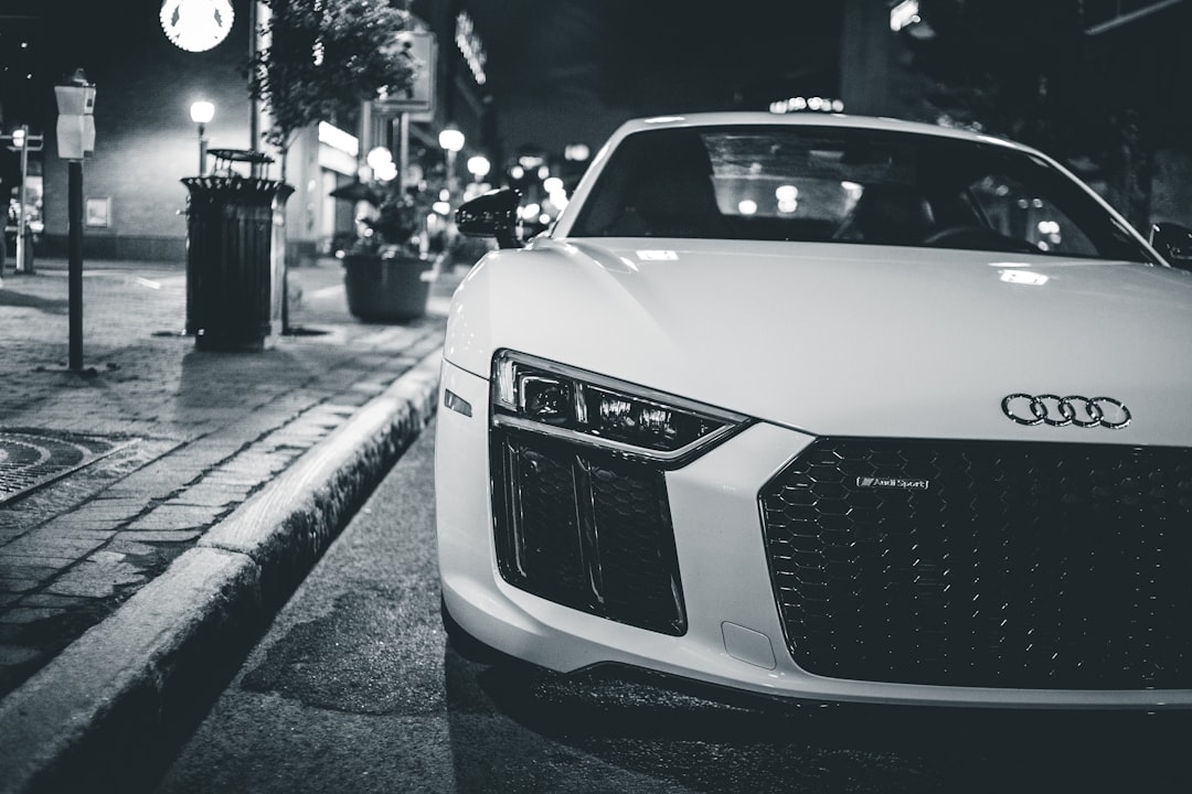 grayscale photography of white Audi R8 on sidewalk
