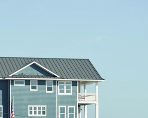 A classic American house with a freshly repaired golden roof under a clear blue sky.