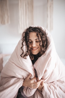 smiling woman wrapped in gray blanket