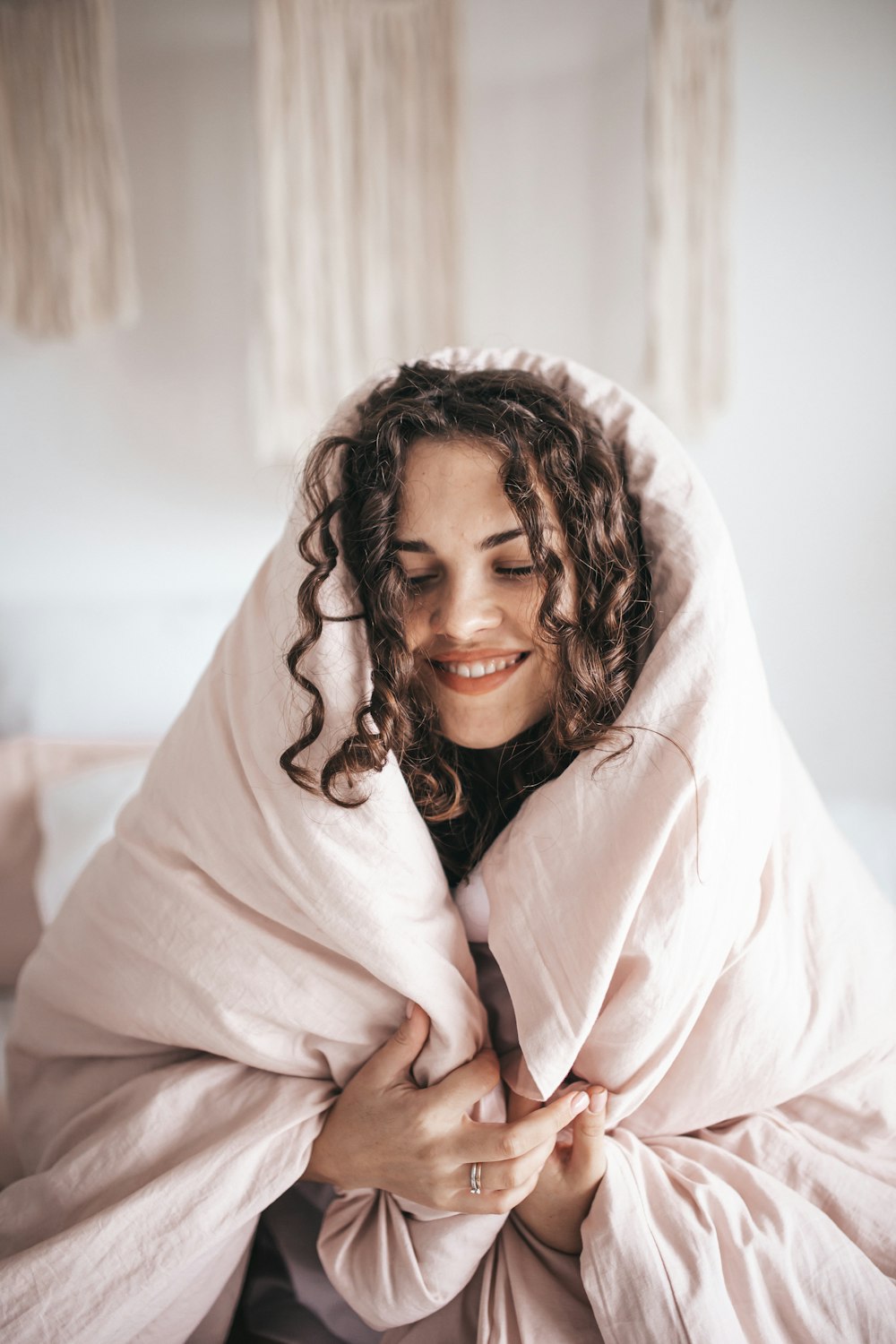 smiling woman wrapped in gray blanket