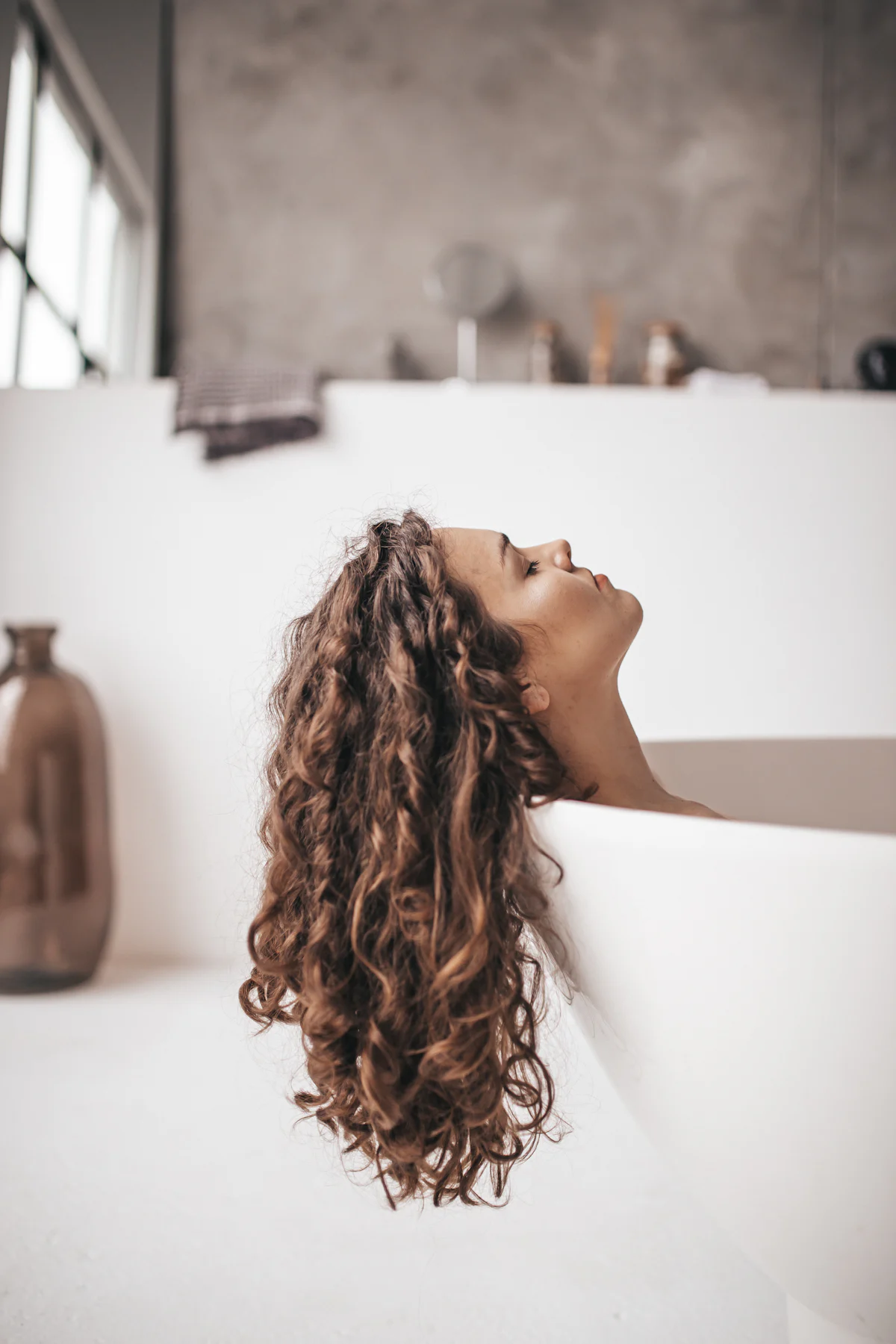 Mujer lavándose el pelo en la bañera